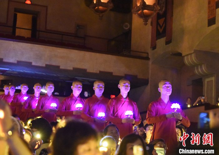 Monks walking in a queue and holding lights.